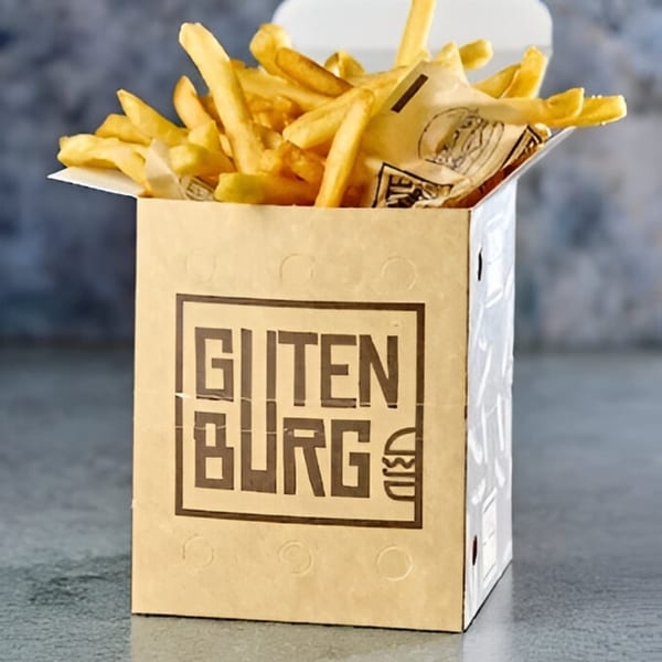 Golden Gutenburg french fries overflowing from a branded cardboard box on a gray surface.